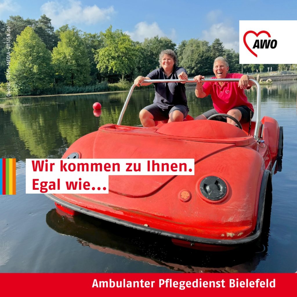 Zwei AWO-Mitarbeitende fahren lachend in einem roten Tretboot über einen See. Text: „Wir kommen zu Ihnen. Egal wie…“